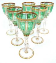 A Set of Six Bohemian Green Glass Wine Goblets, the bowls with cabochon panels within scrolling