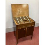 A 1930's Oak Cased Wheeled Cabinet of Optician's Lenses, with lift-up top, sliding shelf and two