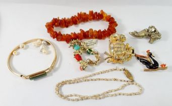 A group of costume jewellery to include amber chip bracelet, scarab style bracelet, pearl necklace