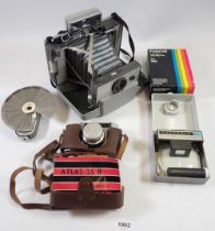 A Polaroid 103 camera, cased and accessories plus an Atlas 35 camera