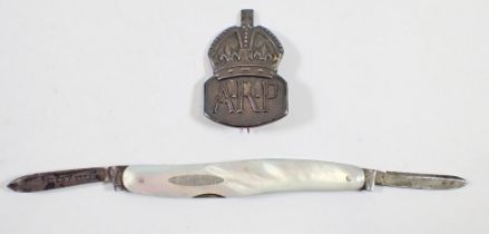 A silver and mother of pearl penknife and an ARP badge