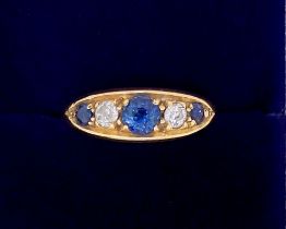 An 18 carat gold ring set three sapphires and two diamonds, marks worn, 2.3 x 1.2cm, size N, 4.6g