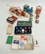 A box of games and toys including mini carpet bowls, advertising playing cards, mechanical bird in