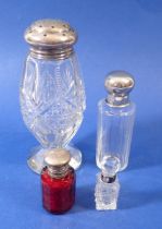 A Victorian cranberry glass smelling salts bottle with silver plated mounts, two other smelling