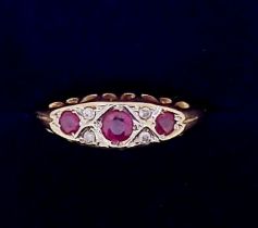 A 9 carat gold ruby three stone ring inset diamonds, 2g, size N