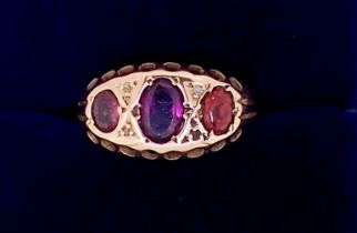 A Victorian 9ct gold ring set three garnets, Size L