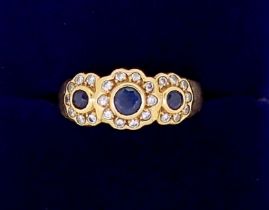 An 18 carat gold ring set triple sapphire and diamond cluster, size N, 4.4g