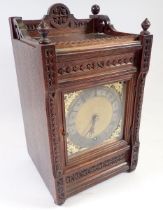 A Victorian oak mantel clock with carved case and brass dial