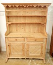A small 19th century pine dresser with three tier back over two drawers and two panelled