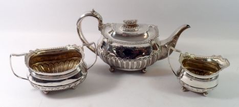 An early 19th century matched silver tea set with scrollwork border and halfgadrooned base, London