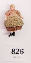 A miniature antique bisque dolls house baby doll with jointed arms and legs and original clothes,