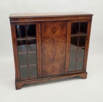 An early 20th century walnut bookcase with two glazed doors flanking panelled door, 101cm high,