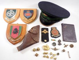 A box of military items including Irish Guards cap and badge, leather pistol holder, copper spitfire