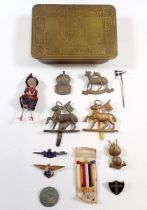 A group of military cap badges, enamel badges, scout badge, miniature doll made from ribbon plus a