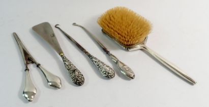 A silver brush, two button hooks, shoe horn and glove stretchers