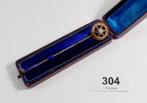 A Victorian yellow metal stick pin with blue enamel and pearl star, cased
