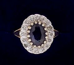 A 9 carat gold oval sapphire ring with white stone surround, 2.7g, size N