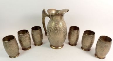 An Indian 'white metal' water jug, 22cm tall and six tumblers with engraved floral decoration