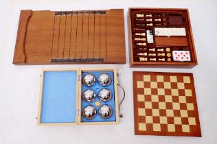 A wooden games compendium, shove ha'penny board and a French boules set