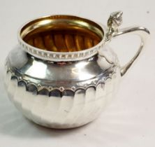 A silver 'Moorish' mug with gilt interior and head thumbpiece, Birmingham 1909 by A E Jones, stamped