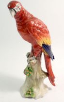 A Sitzendorf porcelain parrot on tree trunk, 24cm