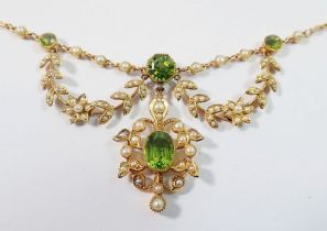 An Edwardian 15ct gold necklace set peridots with seed pearl set flower and leaf surrounds, 11.