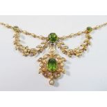 An Edwardian 15ct gold necklace set peridots with seed pearl set flower and leaf surrounds, 11.