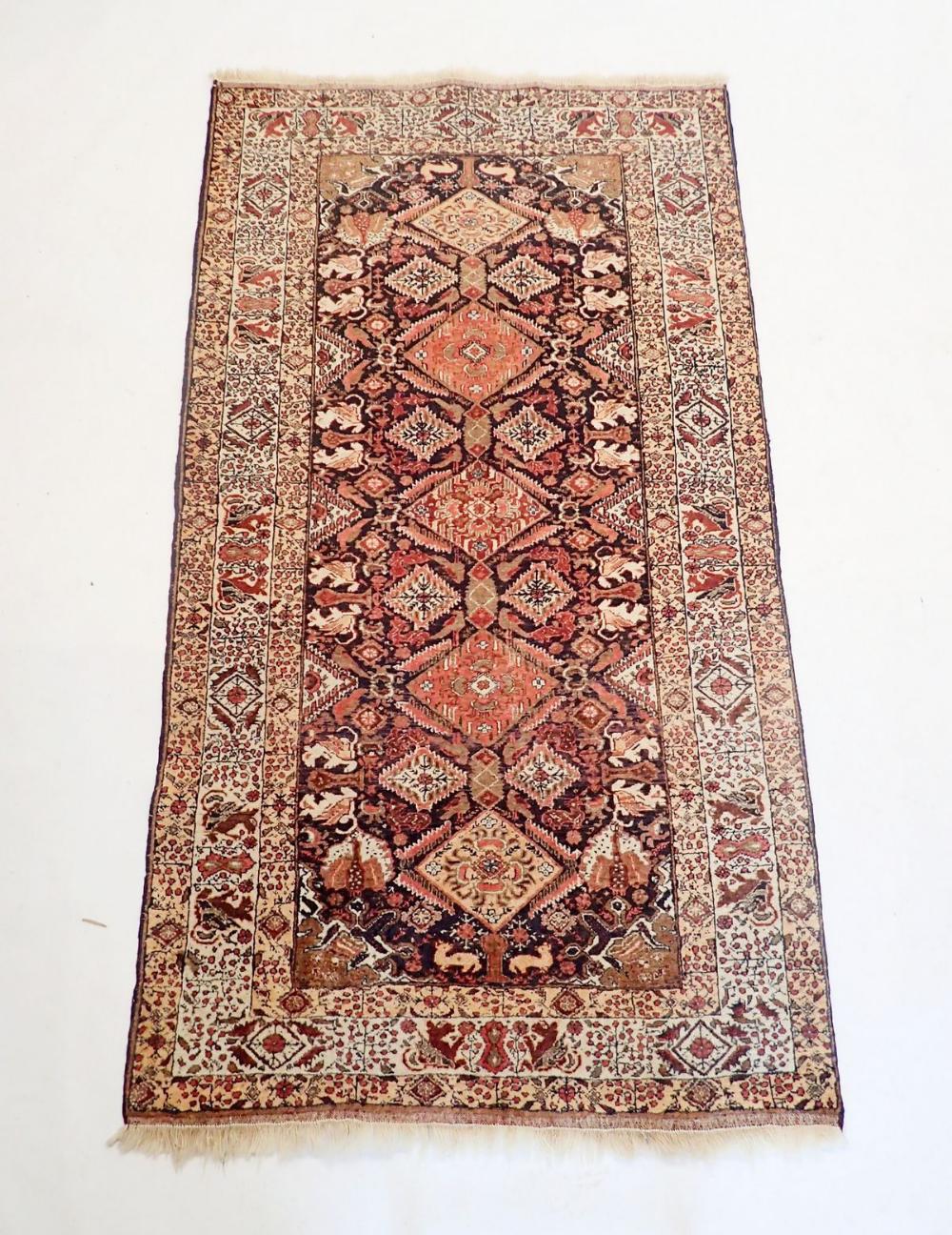 A Persian style rug with coral red and blue lozenge design, 181 x 100cm
