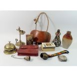 A box of collectables including rush nip holder, stoneware flask, brass table bell etc.