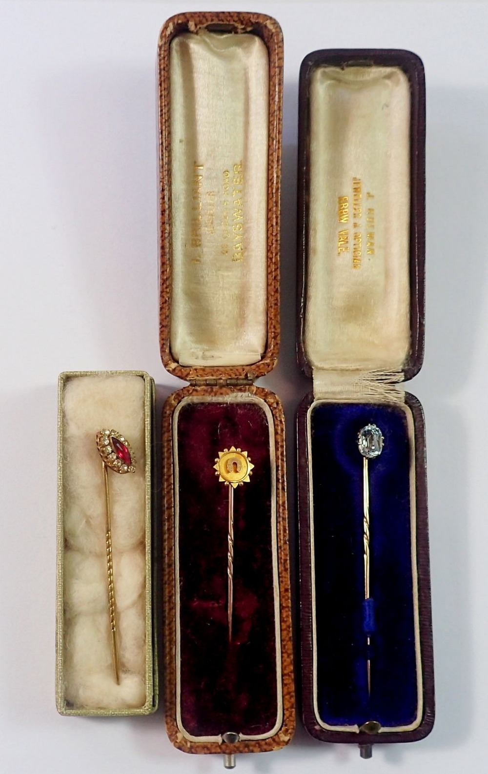 A Victorian 15 carat gold stick pin decorated horseshoe, a 9 carat gold one set aquamarine and a