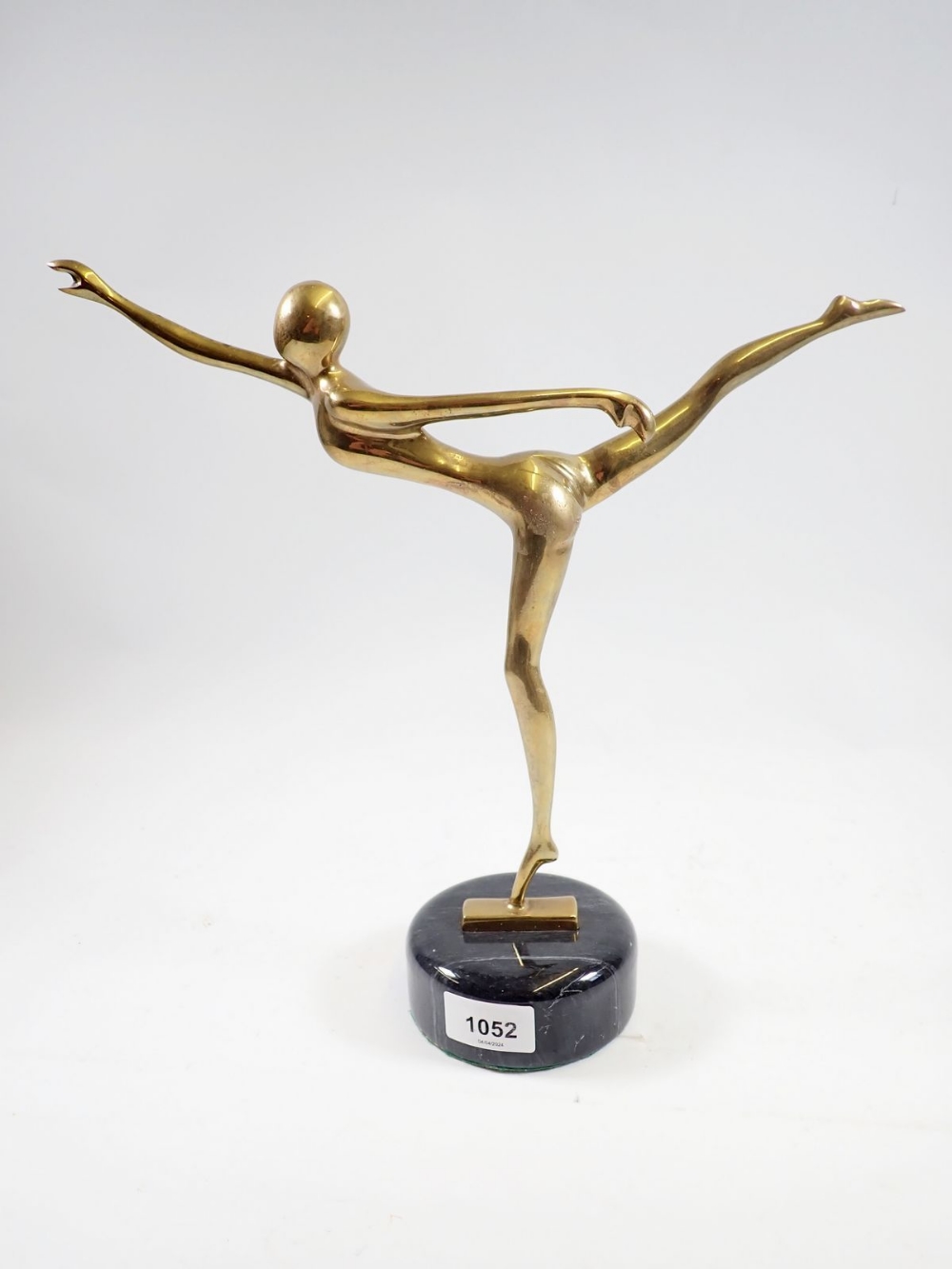 A brass Art Deco stylised figure of a nude dancer on marble base, 32cm tall