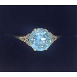 An 18 carat white gold ring set blue zircon on diamond chip shoulders, size P-Q, 2.6g