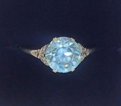 An 18 carat white gold ring set blue zircon on diamond chip shoulders, size P-Q, 2.6g