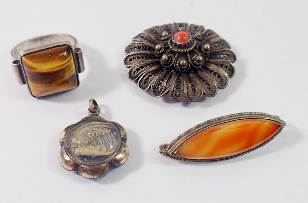 A silver tigers eye ring, yellow metal hair locket, filigree coral brooch (pin a/f) and a white