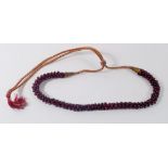 An Eastern garnet bead necklace with metallic thread fastener