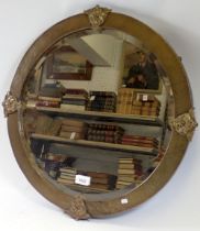 An Art Nouveau brass hammered circular mirror with stylised flowerhead decoration, 56cm diameter