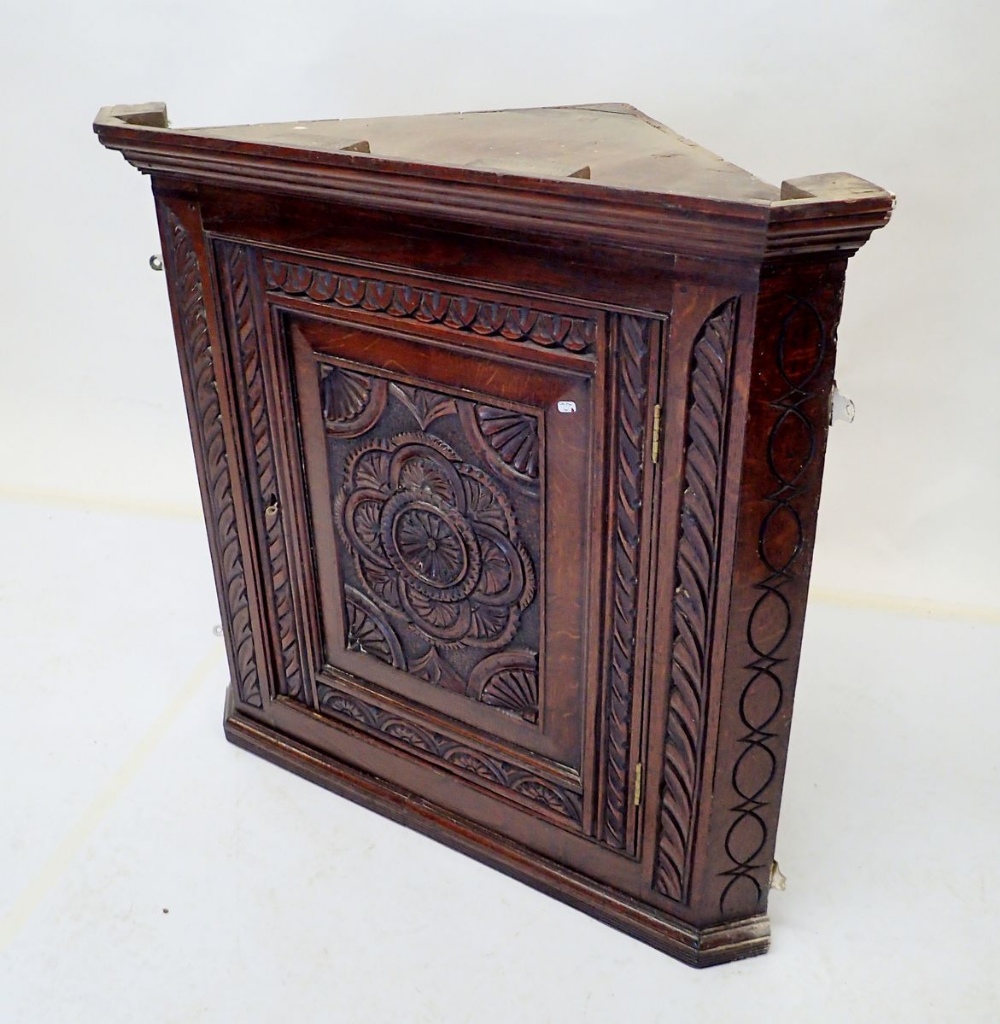 An 18th century oak single door corner cupboard with carved decoration, 78cm tall