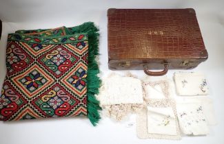 A vintage embroidered Folk art design throw/rug plus items of lace in a leather look suitcase