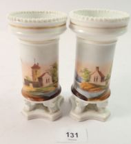 A pair of 19th century continental spill vases painted landscapes on winged paw feet, 14cm