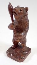 A Black Forrest carved wood bear with club, 12cm tall