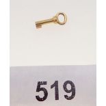 A miniature gold key - unmarked, 1cm long