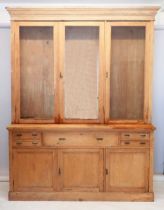 A large 19th century pine farmhouse cabinet with three glazed doors enclosing shelves over four