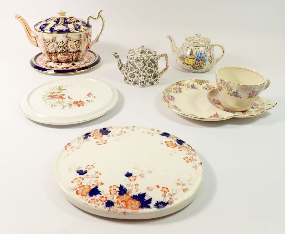 Three Edwardian teapot stands, a tea cup with integral saucer and three teapots