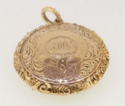 A Victorian gold circular hair locket pendant with engraved decoration 3.5cm diameter