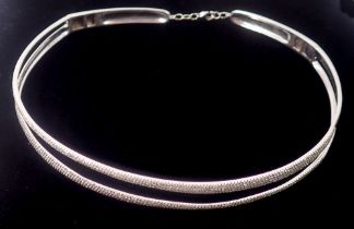 A 14k white gold choker necklace with two asymmetrical narrow bands set round brilliant cut diamonds