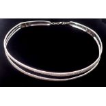 A 14k white gold choker necklace with two asymmetrical narrow bands set round brilliant cut diamonds