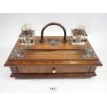 A Victorian oak desk stand with two cut glass inkwells and drawers, 28cm wide