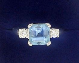 An 18 carat white gold ring set aquamarine flanked by two diamonds, size K to L, 5.5g