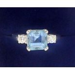 An 18 carat white gold ring set aquamarine flanked by two diamonds, size K to L, 5.5g