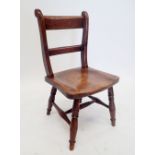 An early 19th century elm seated slat back chair on turned supports